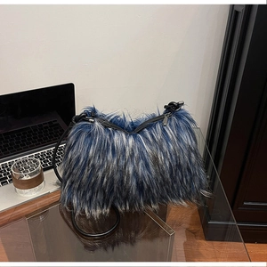 Detail of plush faux fur shoulder bag with blue and black texture and leather strap