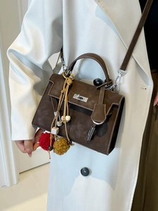 Vintage brown trapezoid shoulder bag with silver turn-lock and colorful bag charm