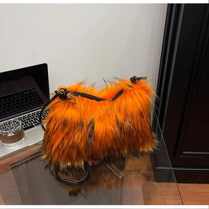 Close-up of fluffy orange and black faux fur texture on a shoulder bag with leather strap