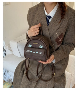 Detail of cute cat face design on vintage brown mini backpack with feline embroidery