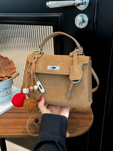Classic camel faux suede handbag with silver turn-lock buckle and decorative fur ball charm