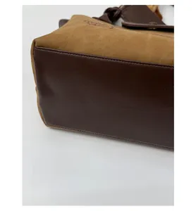 Close-up of widened handbag bottom featuring two-tone leather contrast stitching