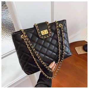 Détail d'un sac matelassé noir avec fermoir tournant doré et finition brillante élégante
