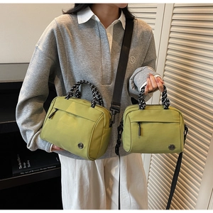 Two sizes of green canvas crossbody bags with woven handles and nylon shoulder straps