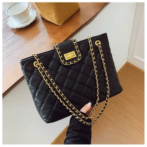 Détail du sac cabas en cuir matelassé noir avec fermoir doré et bandoulière en chaîne