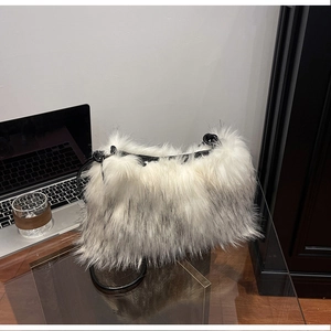 Detail of soft white and grey faux fur texture on a plush shoulder bag with black strap