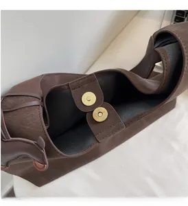 Close-up of brown faux leather bag with dual vintage gold magnetic closures and lining