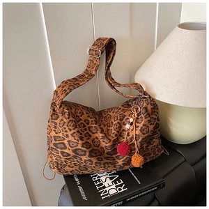 Detail of leopard print hobo bag featuring bohemian tassels and adjustable strap