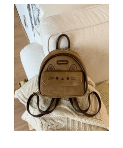 Close-up of a brown suede cat-shaped backpack with embroidered ears and metal logo