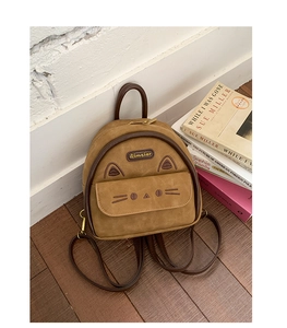Brown mini cat-themed backpack with ears and embroidery against wooden floor