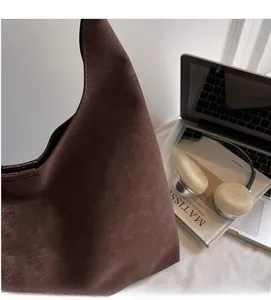 Detail of soft matte dark brown faux leather tote bag with vintage pebble texture