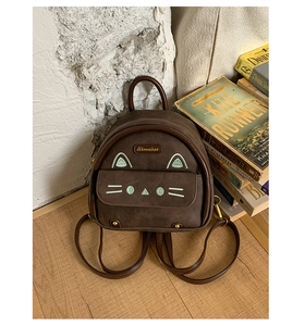 Detail of vintage cat backpack with Aimaior metal logo and retro brown matte leather
