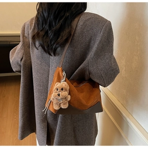 Detailansicht der Vintage-Wildleder-Tasche mit Lederbesatz und Bären-Anhänger