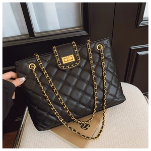 Détail du sac fourre-tout noir matelassé avec chaîne dorée et fermoir pivotant chic