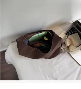 Spacious interior of a dark brown leather tote bag holding a tablet and daily essentials