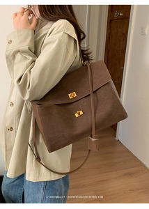 Detail of dark brown suede crossbody bag with elegant golden metallic twist lock