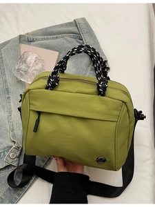 Minimalist grass green nylon crossbody bag with stylish woven handles and black strap