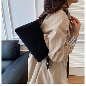 Minimalistische schwarze Matte-Tragetasche an der Schulter in moderner Umgebung