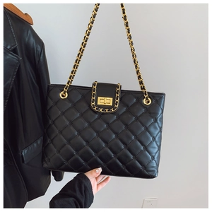 Détail du cuir matelassé noir avec chaîne en métal doré et fermoir rotatif chic