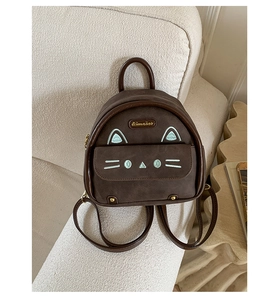 Detail of cute cat embroidery and gold logo on dark brown mini backpack for women