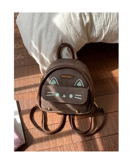 Detail of cute cat-themed mini backpack in brown faux suede with embroidery and chain