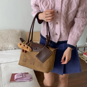 Brown tote bag detail with cute bread illustrations and soft plush bread pendant