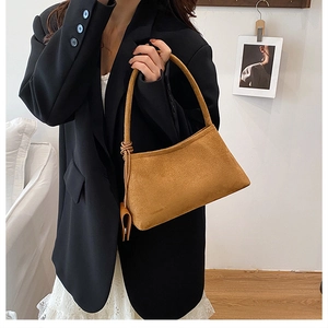 Detail der karamellbraunen Wildledertasche mit Knotengriff und kleiner quadratischer Tasche