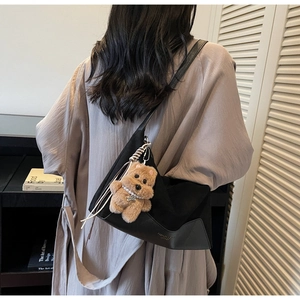 Detailansicht der schwarzen Segeltuch-Tasche mit einem süßen Plüschbären-Anhänger