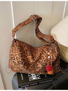 Vintage leopard print shoulder bag with plush charm on a book-style background
