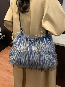 Stylish blue and grey faux fur shoulder bag with leather strap worn with trench coat