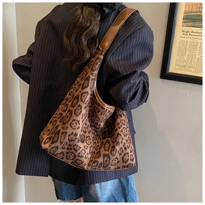 Detail of vintage leopard print tote bag styled with dark striped blazer on model