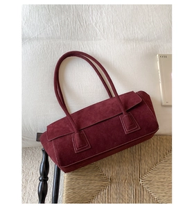 Detailed texture of burgundy suede on minimalist large capacity shoulder handbag