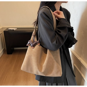 Close-up of large capacity leather shoulder bag with cute dachshund bag charm detail