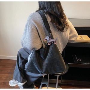 Black matte tote bag with cute brown dachshund leather charm shown in use by a model
