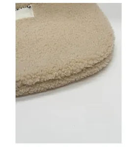 Detail of soft cream plush fabric with EYOU brand label on the stylish underarm bag