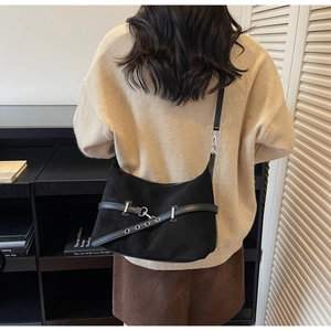 Détail de la bandoulière réglable noire avec œillets argentés sur le sac à main