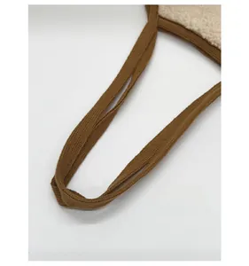 Detail of brown woven shoulder strap with soft beige faux fur fabric stitching
