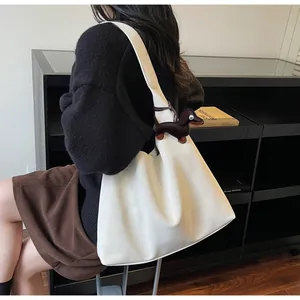 Close-up of minimalist cream tote bag with cute brown dachshund charm on shoulder