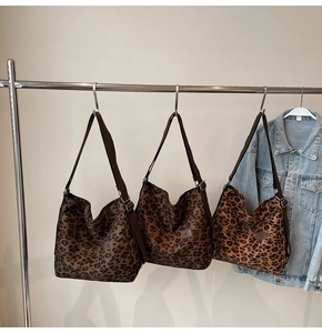 Close-up of three leopard print canvas tote bags in various shades with wide straps