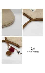 Detailed close-up of soft sherpa fabric underarm bag with refined brown trim and pompom accents
