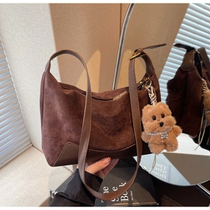 Detail der kaffeebraunen Wildledertasche mit Lederboden und Plüsch-Hundeanhänger
