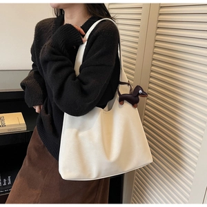 Detail of white large-capacity shoulder hobo bag with cute brown dachshund dog charm