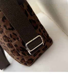Detailed close-up of leopard print canvas tote with adjustable silver metal buckle and strap