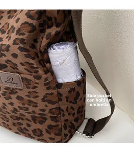 Close-up of leopard print tote canvas bag showing side pocket holding a purple umbrella