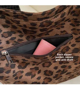 Detail view of anti-theft back zipper pocket on leopard print tote with pink wallet inside