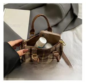 Interior capacity detail showing plaid Boston bag with smartphone and cosmetics