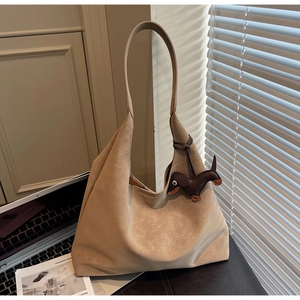 Detail of beige tote bag with vintage texture and dark brown dachshund dog charm