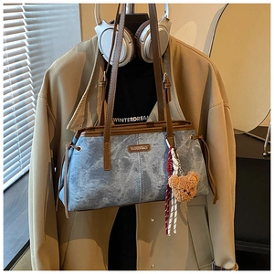 Sac fourre-tout en denim bleu avec bandoulière en cuir brun et breloque ours