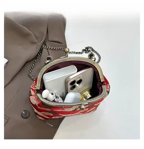 Detail view of the open red crane embroidery bag showing capacity for phone and makeup