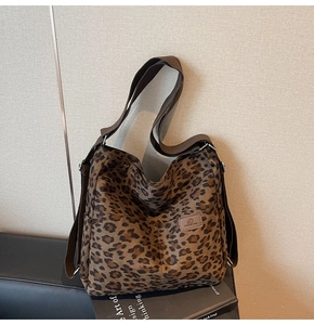 Close-up of leopard print canvas tote bag showing front pocket and logo detail
